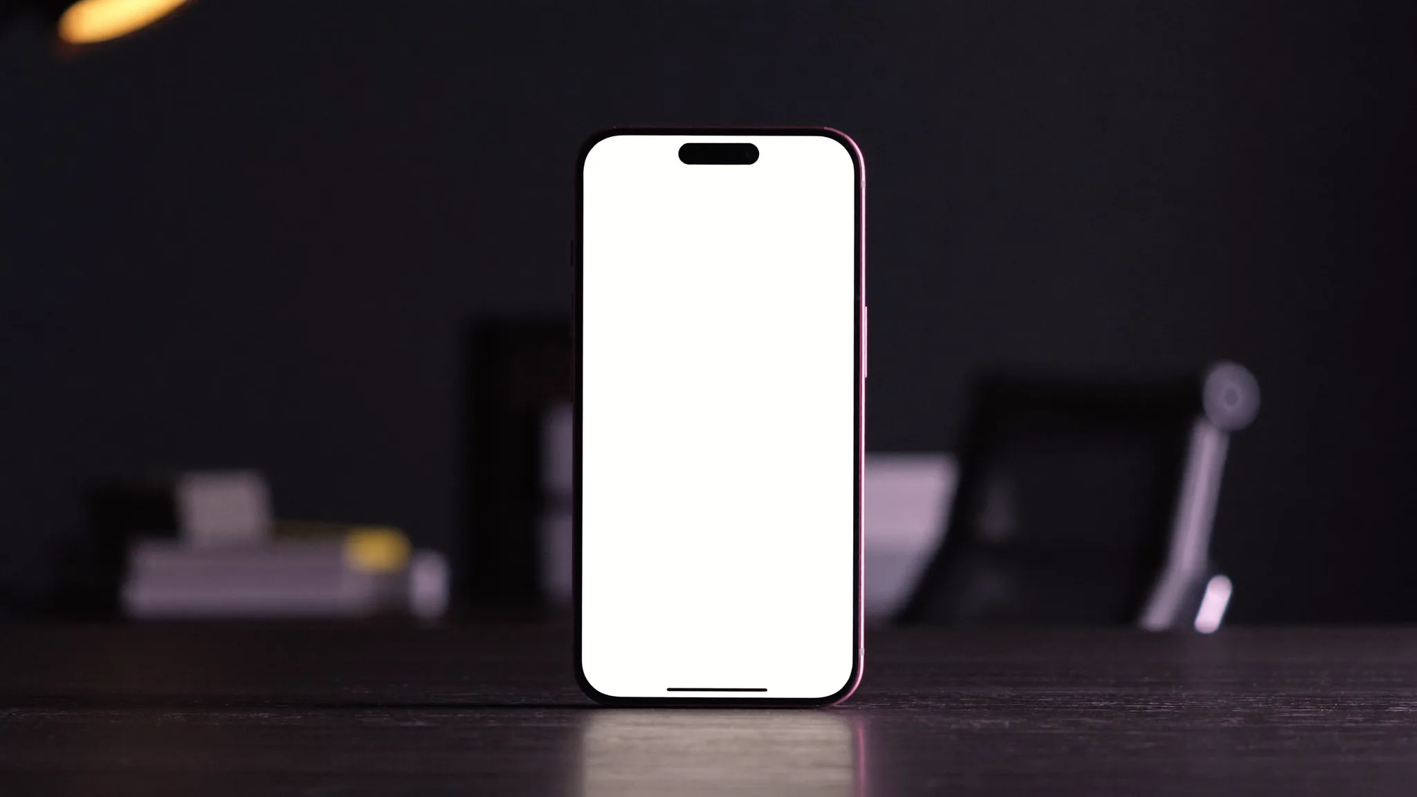 Pametni telefon na tamnom radnom stolu, ilustracija troška AI chatbota za firme u Srbiji